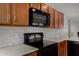 Close up of stainless steel appliances, wood cabinets, and subway tile backsplash at 5621 S 30Th Gln, Phoenix, AZ 85041
