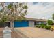 Charming single-story home featuring a blue garage door, a well-maintained lawn, and a mature shade tree at 620 W Crofton St, Chandler, AZ 85225