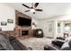 Cozy living room with a brick fireplace, a ceiling fan, a plush sectional, and access to the outdoors at 620 W Crofton St, Chandler, AZ 85225