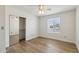 This bedroom includes wood floors, a ceiling fan, a window with blinds, and a mirrored closet at 638 W Pantera Ave, Mesa, AZ 85210