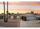 Charming single-story home featuring a two-car garage, brick accents and beautiful desert landscaping at sunset at 638 W Pantera Ave, Mesa, AZ 85210