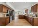 Open kitchen with stainless steel appliances, wooden cabinets, and light hardwood flooring at 638 W Pantera Ave, Mesa, AZ 85210