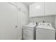 This laundry room includes a Whirlpool washer and dryer and white storage cabinets at 638 W Pantera Ave, Mesa, AZ 85210