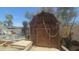 Exterior view of a wooden shed with a simple rope and latch closure, set in a backyard against a blue sky at 6725 W Colter St, Glendale, AZ 85303