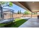 Backyard with outdoor seating, a small trampoline, artificial grass, and string lights at 7634 W Redbird Rd, Peoria, AZ 85383