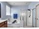 Bright bathroom featuring a soaking tub with a black tray, and glass enclosed shower with dual shower heads at 7634 W Redbird Rd, Peoria, AZ 85383