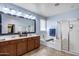 Bathroom featuring double vanity, soaking tub, glass enclosed shower, and neutral tile flooring at 7634 W Redbird Rd, Peoria, AZ 85383