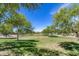 Community common area featuring mature trees, green grass, walking paths and shade at 7634 W Redbird Rd, Peoria, AZ 85383
