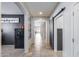 Hallway with neutral color palette, tiled flooring and art on display leading to an open living space at 7634 W Redbird Rd, Peoria, AZ 85383