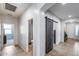 Hallway with tile floors features sliding barn door, access to bathroom and bedroom at 7634 W Redbird Rd, Peoria, AZ 85383