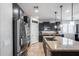 Modern kitchen with stainless steel appliances, granite countertops, black cabinets, and a functional island at 7634 W Redbird Rd, Peoria, AZ 85383