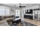 Comfortable living room with gray sectional sofa, dark entertainment center and view to the backyard patio at 7634 W Redbird Rd, Peoria, AZ 85383