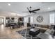 Open concept living room with gray sectional, stylish rug, kitchen island and dining table at 7634 W Redbird Rd, Peoria, AZ 85383
