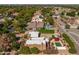 An aerial view shows the house with a white roof, pool, landscaping, and a red gazebo at 8675 S College Ln, Tempe, AZ 85284