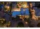 Aerial view showcases a home's pool, manicured yard, and circular driveway at night at 8675 S College Ln, Tempe, AZ 85284