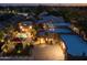 Expansive estate with a pool, spa, guest house and a large circular driveway, all illuminated at twilight at 8675 S College Ln, Tempe, AZ 85284