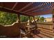 Balcony with pergola offers a cozy seating area overlooking mature trees and landscaping at 8675 S College Ln, Tempe, AZ 85284