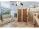 Bathroom featuring a walk-in shower, soaking tub, dual sinks, and travertine flooring at 8675 S College Ln, Tempe, AZ 85284
