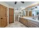 Bathroom featuring a walk-in shower, dual sinks, plenty of vanity space, and custom cabinetry at 8675 S College Ln, Tempe, AZ 85284