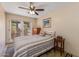 Cozy bedroom featuring a sliding glass doors, ceiling fan, striped bedspread, and natural lighting at 8675 S College Ln, Tempe, AZ 85284