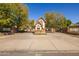 Charming gated community entrance with Tudor-style guard house and brick signage with mature trees at 8675 S College Ln, Tempe, AZ 85284