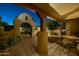 Night view of courtyard with fountain, custom gate, mature trees, and covered seating area at 8675 S College Ln, Tempe, AZ 85284