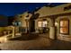 Night view of the courtyard featuring a fountain, covered patio with elegant seating, and lush landscaping at 8675 S College Ln, Tempe, AZ 85284
