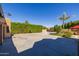 Long driveway and desert landscaping with a palm tree in the yard next to a red gazebo at 8675 S College Ln, Tempe, AZ 85284