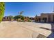 Wide driveway and desert landscaping with a palm tree in the yard next to a red gazebo at 8675 S College Ln, Tempe, AZ 85284