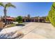 Stunning single-story home featuring a desert landscape, a large driveway, and a covered patio with seating at 8675 S College Ln, Tempe, AZ 85284