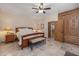 Bedroom showcases a king bed, an ensuite entrance, a ceiling fan, and custom built-ins at 8675 S College Ln, Tempe, AZ 85284
