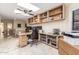 Spacious home office with a granite desk, built-in bookshelves, a ceiling fan, and natural lighting at 8675 S College Ln, Tempe, AZ 85284