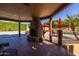 Charming covered patio featuring an outdoor fireplace and comfortable seating with picturesque backyard view at 8675 S College Ln, Tempe, AZ 85284