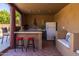 Outdoor kitchen with bar, refrigerator, and seating area provides ample space for entertaining at 8675 S College Ln, Tempe, AZ 85284