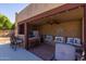 Outdoor kitchen with bar seating, refrigerator, ceiling fan, and built-in benches at 8675 S College Ln, Tempe, AZ 85284