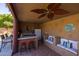 Outdoor kitchen featuring bar, refrigerator, ceiling fan, and cozy seating area with cushions at 8675 S College Ln, Tempe, AZ 85284