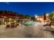 Well-lit backyard pool with spacious outdoor dining area, highlighted by desert landscaping, offering evening relaxation at 8675 S College Ln, Tempe, AZ 85284