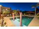 Backyard showcasing sparkling pool with in-water seating, next to an outdoor dining table and manicured desert landscaping at 8675 S College Ln, Tempe, AZ 85284