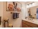 Quaint half bathroom with decorative accents, a large mirror, and stylish lighting fixtures at 8675 S College Ln, Tempe, AZ 85284