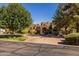 Inviting house with mature landscaping and a circular driveway, creating a welcoming curb appeal in a peaceful neighborhood setting at 8675 S College Ln, Tempe, AZ 85284