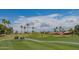 Beautiful golf course view with lush green grass, mature palm trees, and blue sky in a residential community at 8839 W Rimrock Dr, Peoria, AZ 85382