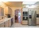 Bright kitchen offering white cabinets and stainless-steel appliances, and view of a living area with a fireplace at 8839 W Rimrock Dr, Peoria, AZ 85382