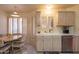Eat-in kitchen featuring white cabinets, tile countertops, stainless steel dishwasher, and a cozy dining area at 8839 W Rimrock Dr, Peoria, AZ 85382