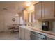 Well-lit kitchen featuring white cabinets, tile countertops, stainless steel appliances, and an adjacent dining area at 8839 W Rimrock Dr, Peoria, AZ 85382