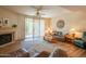 Comfortable living room with fireplace, patio access, and a ceiling fan, offering a relaxing atmosphere at 8839 W Rimrock Dr, Peoria, AZ 85382