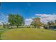 Putting green with colorful trees and lush grass in a residential community at 8839 W Rimrock Dr, Peoria, AZ 85382