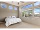 Sunny bedroom with large windows showcases a ceiling fan, carpeted floor, and natural light at 9715 E Allison Way, Scottsdale, AZ 85262