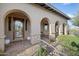 Welcoming front entrance with a decorative glass door, arched columns, and desert landscaping at 9715 E Allison Way, Scottsdale, AZ 85262