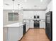Stylish kitchen with white cabinetry, pendant lighting, and sleek black appliances at 9829 E Talon Ave, Mesa, AZ 85212