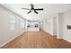 Bright living room with hardwood floors seamlessly connects to a kitchen with white cabinets and stainless appliances at 9829 E Talon Ave, Mesa, AZ 85212